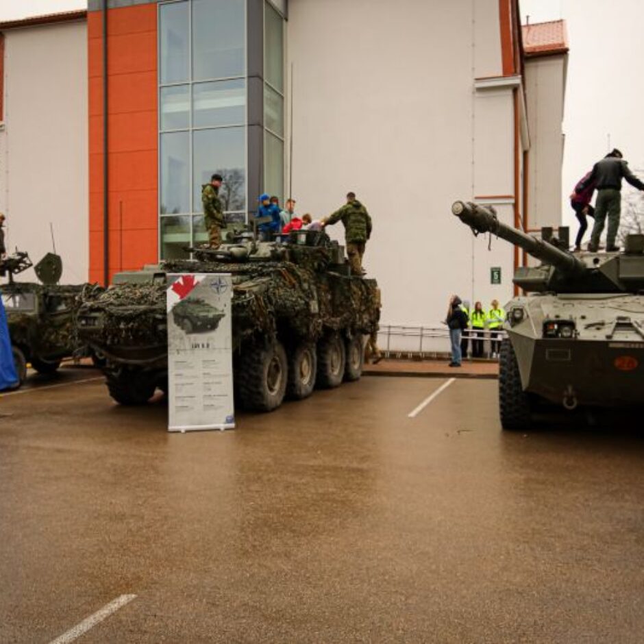 Latvijas armijas izstāde-2 tanki pie skolas uz kuriem ir bērni un karavīri